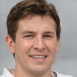 Joyful white adult male with short  brown hair and brown eyes