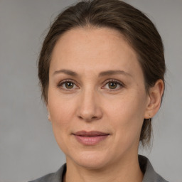 Joyful white adult female with medium  brown hair and grey eyes