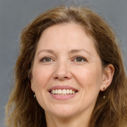 Joyful white adult female with long  brown hair and grey eyes