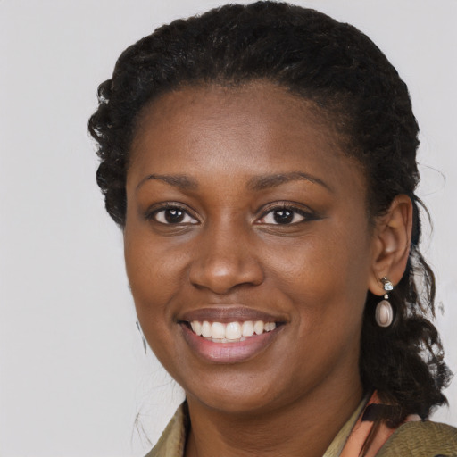 Joyful black young-adult female with long  brown hair and brown eyes
