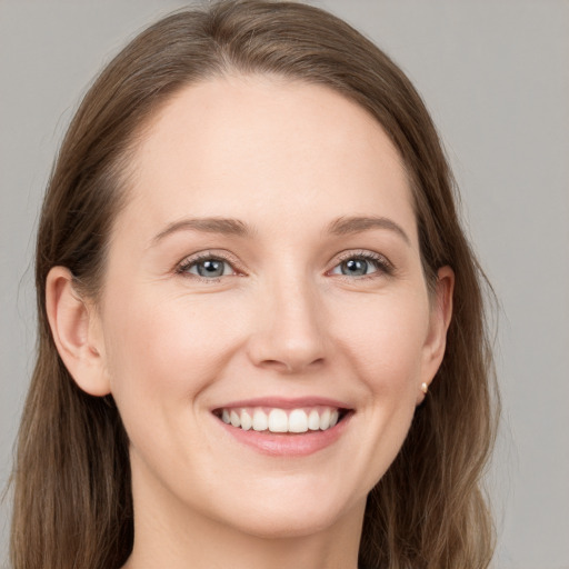 Joyful white young-adult female with long  brown hair and grey eyes