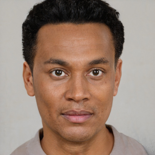 Joyful black young-adult male with short  black hair and brown eyes