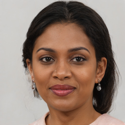 Joyful black adult female with medium  brown hair and brown eyes
