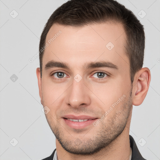 Joyful white young-adult male with short  brown hair and brown eyes