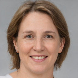 Joyful white adult female with medium  brown hair and grey eyes