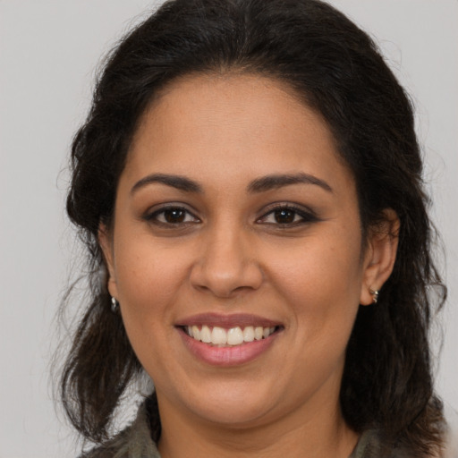 Joyful latino young-adult female with long  brown hair and brown eyes