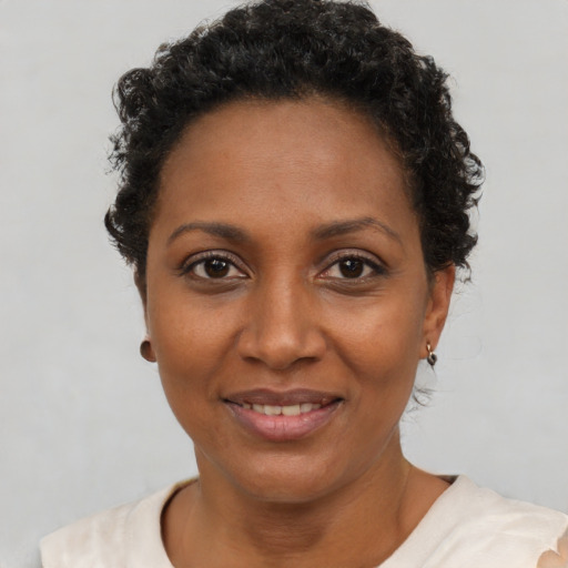 Joyful black adult female with short  brown hair and brown eyes