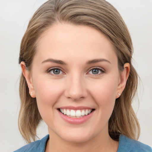 Joyful white young-adult female with medium  brown hair and blue eyes