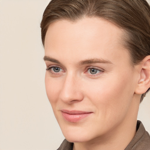 Joyful white young-adult female with short  brown hair and grey eyes