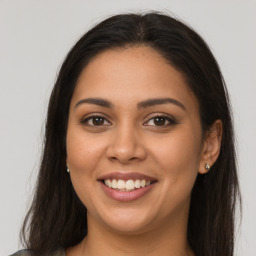 Joyful latino young-adult female with long  brown hair and brown eyes