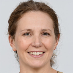 Joyful white adult female with medium  brown hair and grey eyes