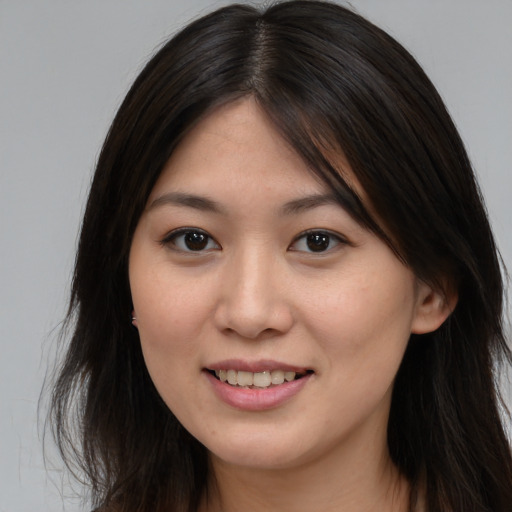 Joyful asian young-adult female with long  brown hair and brown eyes