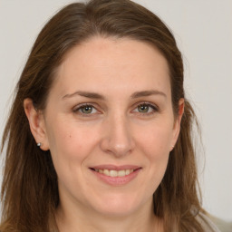 Joyful white young-adult female with long  brown hair and grey eyes