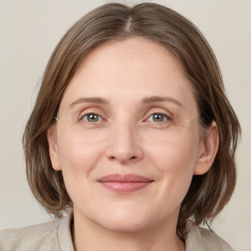 Joyful white adult female with medium  brown hair and grey eyes