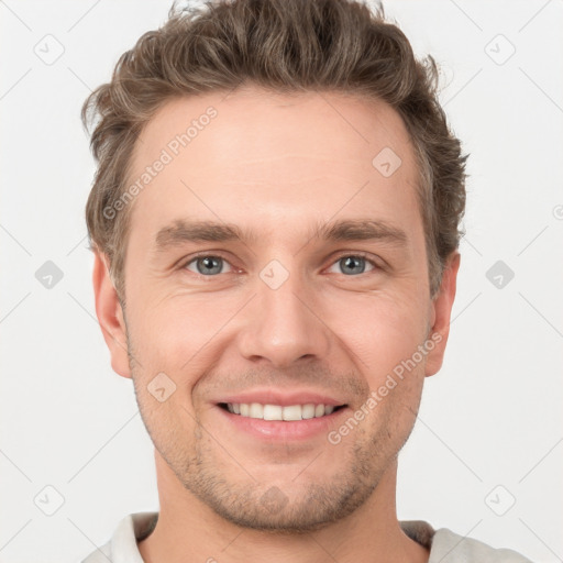 Joyful white young-adult male with short  brown hair and grey eyes