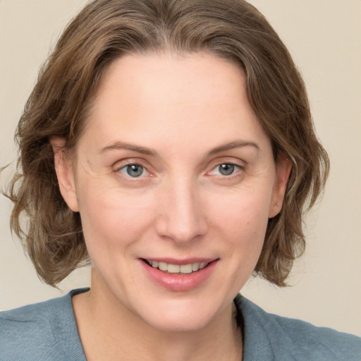 Joyful white adult female with medium  brown hair and grey eyes