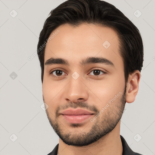 Joyful white young-adult male with short  black hair and brown eyes