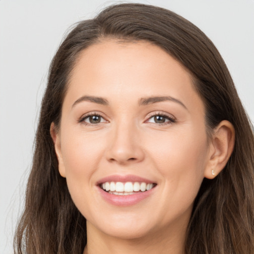 Joyful white young-adult female with long  brown hair and brown eyes