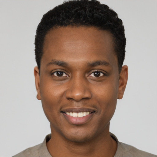 Joyful black young-adult male with short  black hair and brown eyes