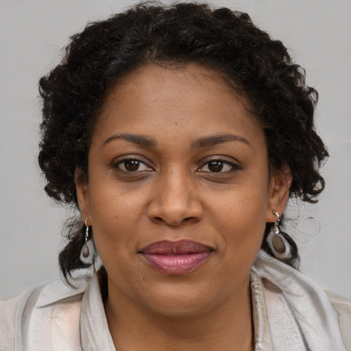Joyful black young-adult female with long  brown hair and brown eyes