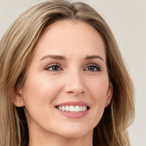 Joyful white young-adult female with long  brown hair and green eyes