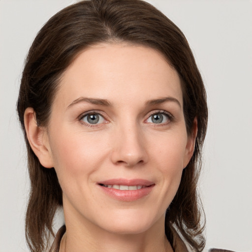 Joyful white young-adult female with medium  brown hair and grey eyes