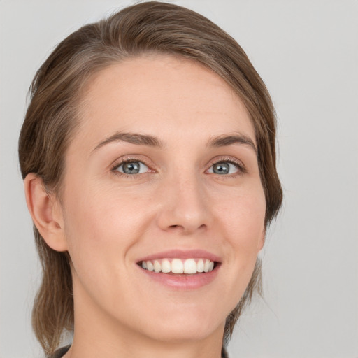 Joyful white young-adult female with medium  brown hair and green eyes