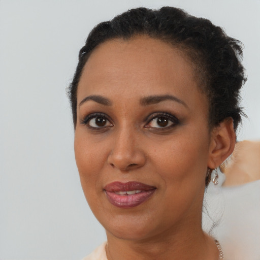Joyful black young-adult female with short  brown hair and brown eyes
