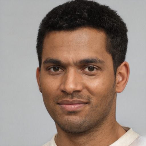 Joyful black young-adult male with short  black hair and brown eyes