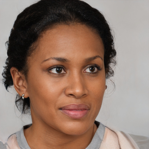 Joyful black young-adult female with medium  brown hair and brown eyes
