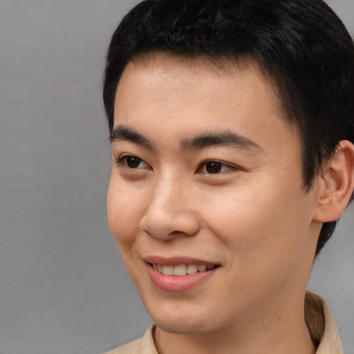 Joyful asian young-adult male with short  brown hair and brown eyes
