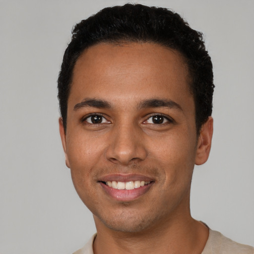 Joyful latino young-adult male with short  black hair and brown eyes