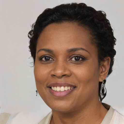 Joyful black young-adult female with short  black hair and brown eyes