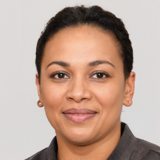 Joyful latino adult female with short  brown hair and brown eyes