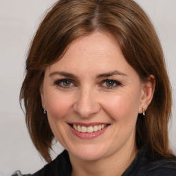 Joyful white adult female with medium  brown hair and grey eyes