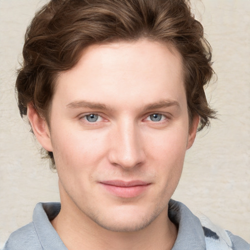 Joyful white young-adult male with short  brown hair and blue eyes