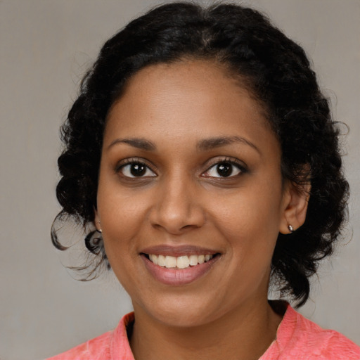 Joyful black young-adult female with medium  brown hair and brown eyes