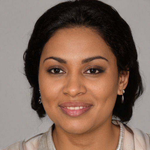 Joyful black young-adult female with medium  brown hair and brown eyes