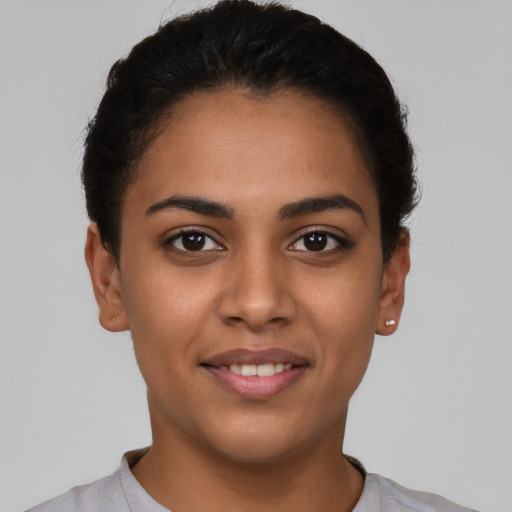 Joyful latino young-adult female with short  brown hair and brown eyes