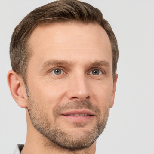 Joyful white adult male with short  brown hair and brown eyes