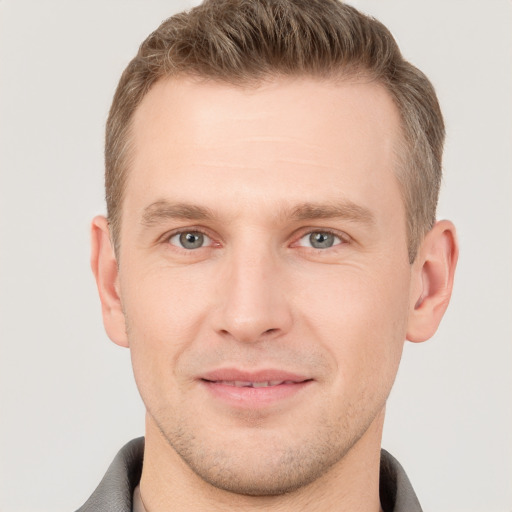 Joyful white young-adult male with short  brown hair and grey eyes