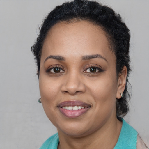Joyful black young-adult female with long  brown hair and brown eyes