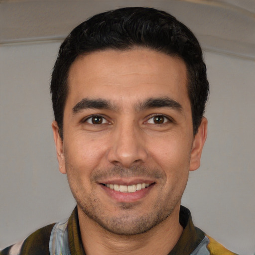 Joyful white young-adult male with short  black hair and brown eyes