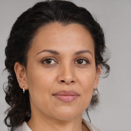 Joyful latino adult female with medium  brown hair and brown eyes