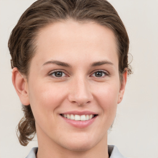 Joyful white young-adult female with medium  brown hair and grey eyes