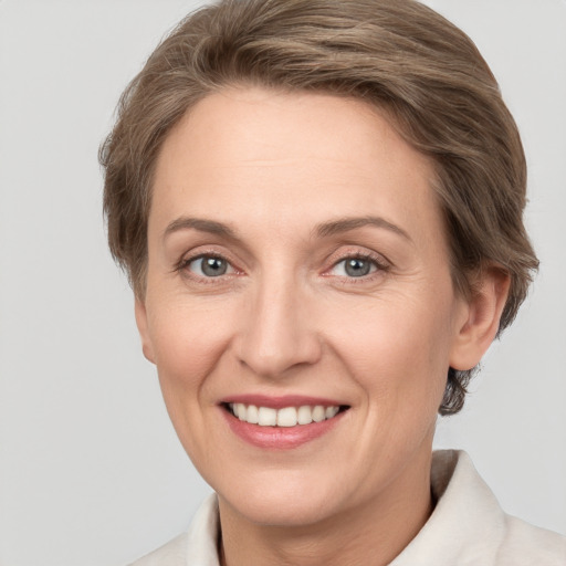 Joyful white adult female with medium  brown hair and grey eyes