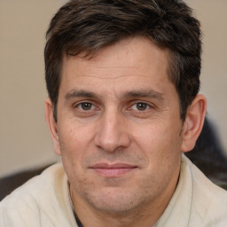 Joyful white adult male with short  brown hair and brown eyes