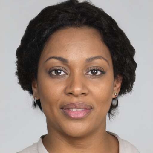 Joyful black adult female with short  black hair and brown eyes