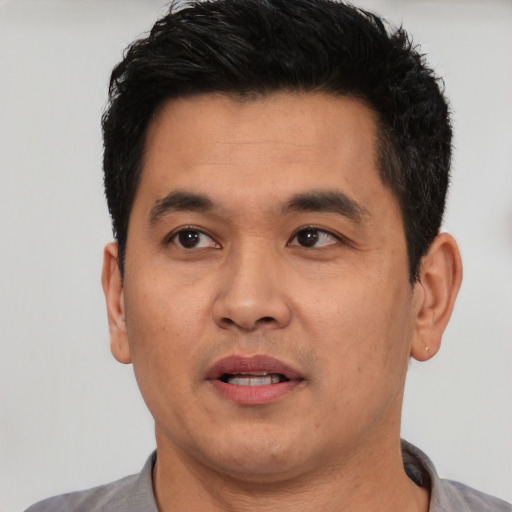 Joyful white young-adult male with short  black hair and brown eyes