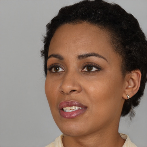 Joyful black young-adult female with medium  black hair and brown eyes
